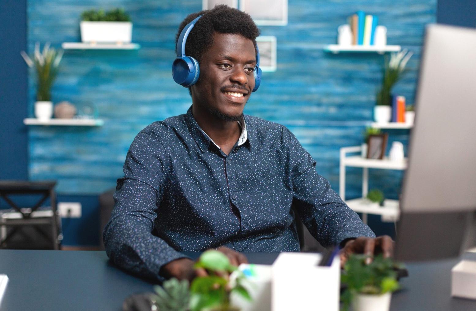 Person arbeitet konzentriert an Finanzplanung mit verschiedenen Dokumenten und Laptop